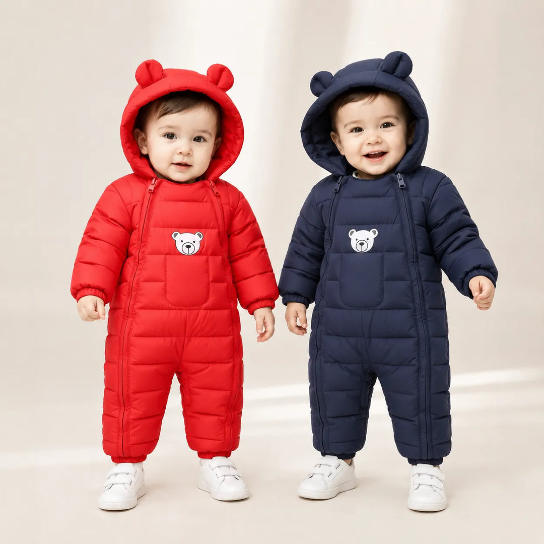 Dois bebês modelos usando macacões infantis acolchoados vermelho e azul-marinho com capuz de ursinho em ensaio profissional de estúdio Varialle.